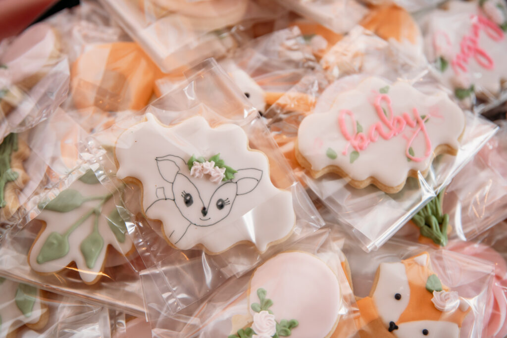 Pink and baby deer-themed decorations at a baby shower in Churchville, NY park
